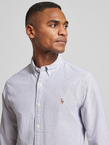 Männermodel trägt Slim Fit Freizeithemd mit Button-Down-Kragen von Polo Ralph Lauren aus reiner Baumwolle mit Label-Stitching, Nahaufnahme Oberkörper.