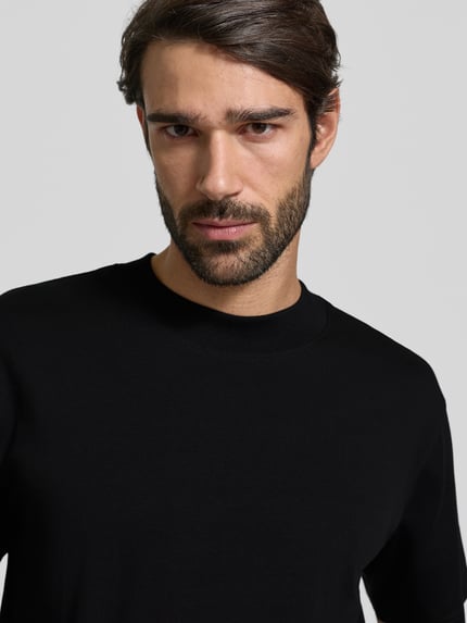 Männermodel trägt Regular Fit T-Shirt aus reiner Baumwolle Modell 'COLMAN' von SELECTED HOMME, unifarben, Nahaufnahme Oberkörper.