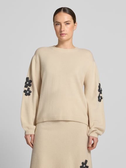 Frauenmodel trägt Strickpullover aus Wolle mit Stitchings und Perlen von Christian Berg Woman, Beige, Relaxed Fit, Rundhalsausschnitt, Ganzkörperansicht von vorne.
