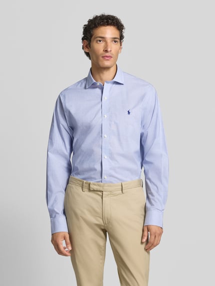 Männermodel trägt hellblaues Slim Fit Businesshemd aus reiner Baumwolle von Polo Ralph Lauren, glatte Textur, Ganzkörperansicht von vorne.