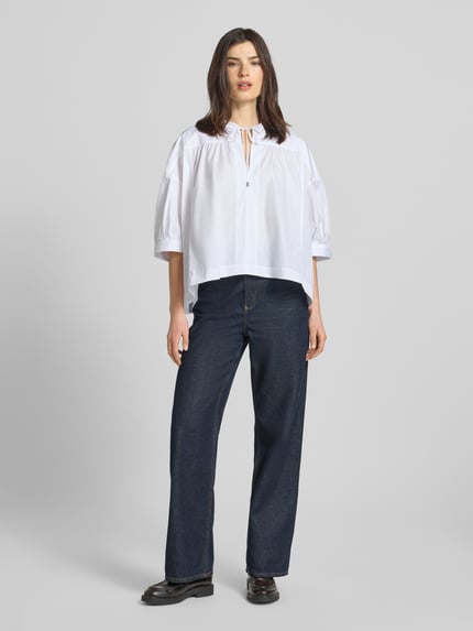 Frauenmodel trägt Oversized Bluse aus reiner Baumwolle Modell 'Bollana' von BOSS, Optik: Unifarben, Passform: Oversized, Kragenform: Tunika, Ausschnitt: Schlüsselloch, Verschluss: Knebelverschluss, Ärmelform: Kurzarm, Materialverarbeitung: Popeline, Material: reine Baumwolle, weiß, ganzkörperansicht von vorne.