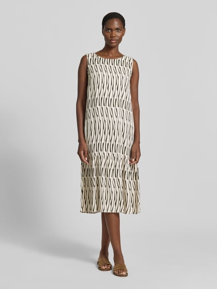 Vrouwenmodel draagt Midikleid met rückseitigem Schlüsselloch-Ausschnitt van OPUS, zuiver viscose, recht model, model 'Wicy bamboo', ronde hals, crème met zwart patroon, ruglengte maat 36: 115 cm, borstwijdte: 49 cm. Ganzkörperansicht van voren.
