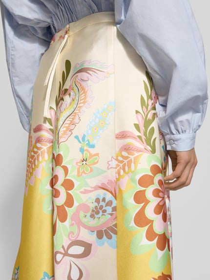 Frauenmodel trägt Midirock aus Satin im Allover-Look von HERZENS mit A-Linie, Teilungsnähte, florale Muster, Nahaufnahme Rückansicht.