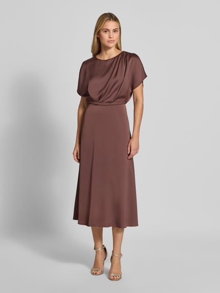 Frauenmodel trägt Midikleid aus Satin von SWING in Braun, taillierte Passform, Rundhalsausschnitt, kurzärmelig, Ganzkörperansicht von vorne.