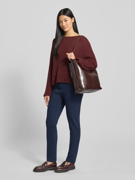 Kobiece modelka nosi granatowe Stoffhose mit französischen Eingrifftaschen Modell 'Lillyth' od Raphaela By Brax z prostym krojem, materiał z domieszką wiskozy, kieszenie francuskie, zapięcie na guzik i zamek, widok całej sylwetki z przodu.