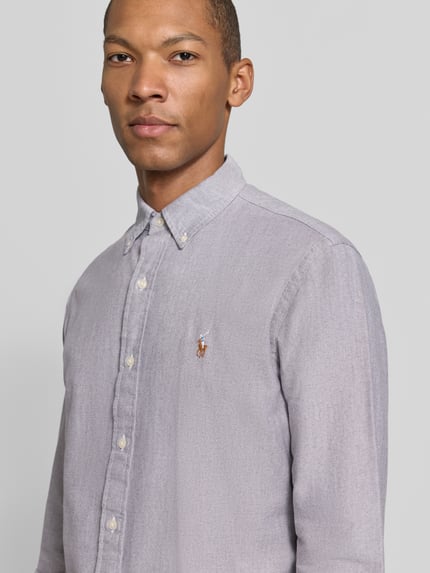 Männermodel trägt Freizeithemd mit Logo-Stickerei von POLO RALPH LAUREN aus reiner Baumwolle, unifarben, Nahaufnahme Oberkörper.