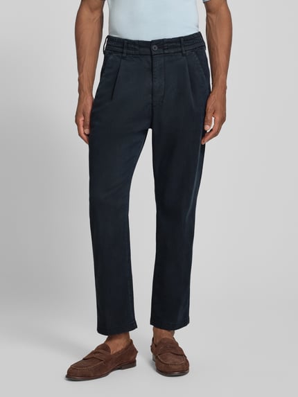 Männermodel trägt Regular Fit Hose mit Eingrifftaschen Modell 'CHASY' von DRYKORN im Lyocell-Mix mit Baumwoll-Anteil, dunkelblau, Ganzkörperansicht von vorne. Bundweite 41 cm, Innenbeinlänge 71 cm, Gesäßtaschen.