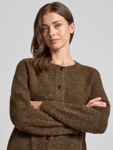 Frauenmodel trägt Relaxed Fit Strickjacke aus Woll-Mix Modell 'LULU' von Selected in braun, grobe Textur, Nahaufnahme Oberkörper, Damen Strickjacke.