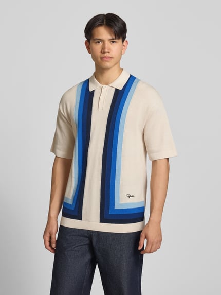 Männermodel trägt Relaxed Fit Poloshirt in Strick-Optik Modell 'Tellero' von Pegador, Reine Baumwolle, Kurzärmelig, Polokragen, Ganzkörperansicht von vorne.