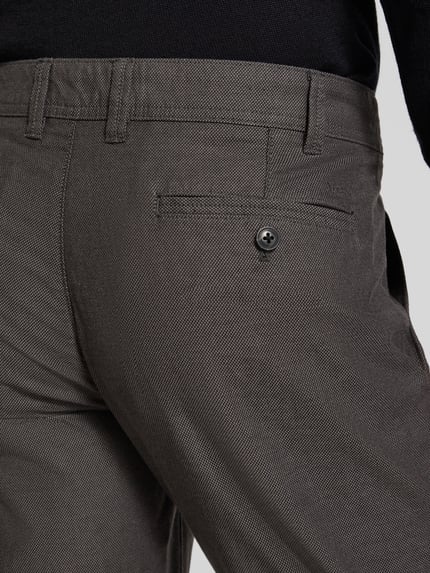 Männermodel trägt Stoffhose mit französischen Eingrifftaschen von MCNEAL aus Baumwoll-Elasthan-Mix, Detailaufnahme Gesäßtasche.
