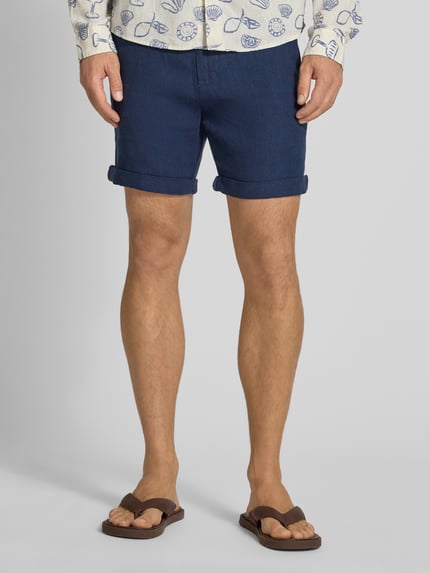 Männermodel trägt Leinenshorts met strikceintuur en strookzak aan de achterkant van MCNEAL, zuiver linnen, straight fit, knoop- en ritssluiting, steekzakken, pijpomslag, labelstitching, bandwijdte maat M 45 cm, binnenbeenlengte 16 cm, ganzkörperansicht van voren.