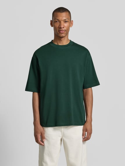 Männermodel trägt grünes Regular Fit T-Shirt aus reiner Baumwolle Modell 'HASPEN' von SELECTED HOMME, Herren T-Shirt, Ganzkörperansicht von vorne.
