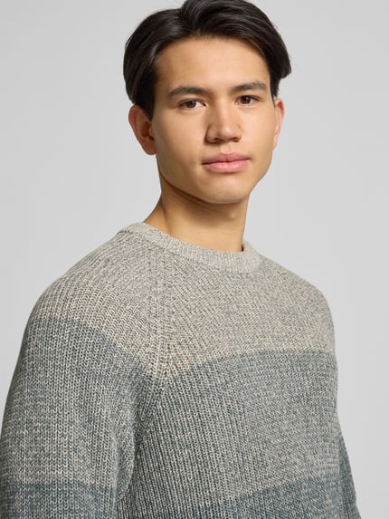 Männermodel trägt Relaxed Fit Strickpullover aus reiner Baumwolle Modell 'BIRK' von Only & Sons, melierte Ombré-Optik, Nahaufnahme Oberkörper.