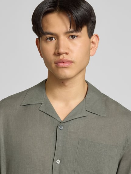 Männermodel trägt Relaxed Fit Freizeithemd aus leinen-viscose-mix Modell 'LAURENCE' von Only & Sons, unifarben, reverskraag, borstzak, eenrijige knopen, nahaufnahme oberkörper