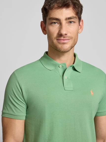 Męski model nosi Poloshirt mit Label-Stitching od Polo Ralph Lauren, jasna zieleń, bawełna, regular fit, krótka lista guzików, półzbliżenie tułowia.