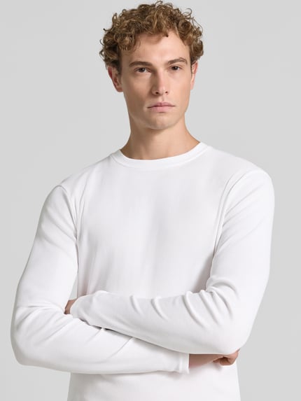 Mannenmodel draagt Slim Fit Longsleeve uit puur katoen Model 'Enil' van DRYKORN, structuurpatroon, ronde hals, detailopname bovenlichaam.