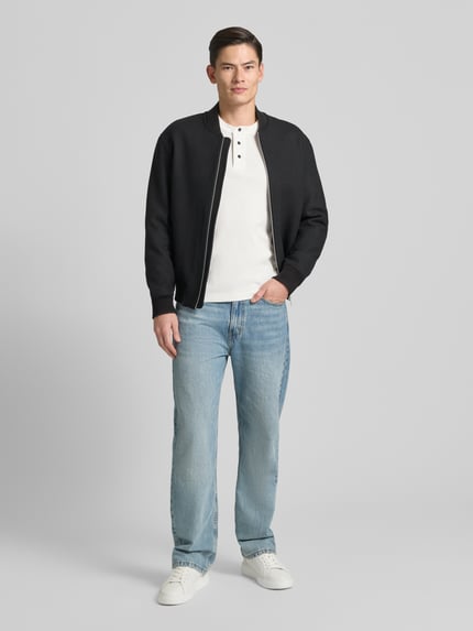 Männermodel trägt Sweatshirt mit gerippten Abschlüssen von ARMANI EXCHANGE in Weiß, reine Baumwolle, Regular Fit, Ganzkörperansicht von vorne.