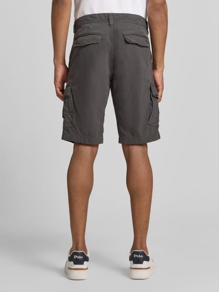 Männermodel trägt Bermudas mit Pattentaschen und Label-Stitchings von PME Legend in Dunkelgrau, Straight Fit, Ganzkörperansicht Rückansicht. 