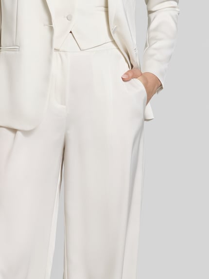 Frauenmodel trägt Hose mit weitem Bein und Falten von Jake*s Cocktail in Weiß, Satin mit Gesäßtasche, Nahaufnahme Oberkörper.
