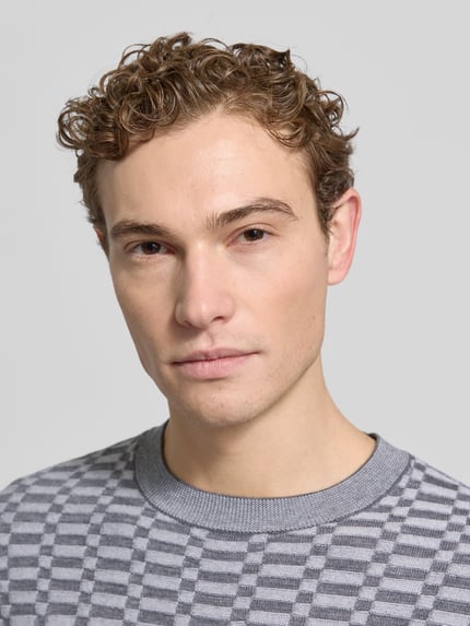 Männermodel trägt Strickpullover mit gerippten Abschlüssen von Emporio Armani, Reine Schurwolle, Regular-Fit, Nahaufnahme Oberkörper.