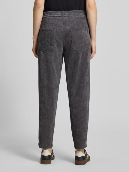 Frauenmodel trägt Regular Fit Barrel Leg Hose mit Cordstruktur von CAMBIO, unifarbene, strukturierte Optik, 5-Pocket-Design, Ganzkörperansicht Rückansicht.