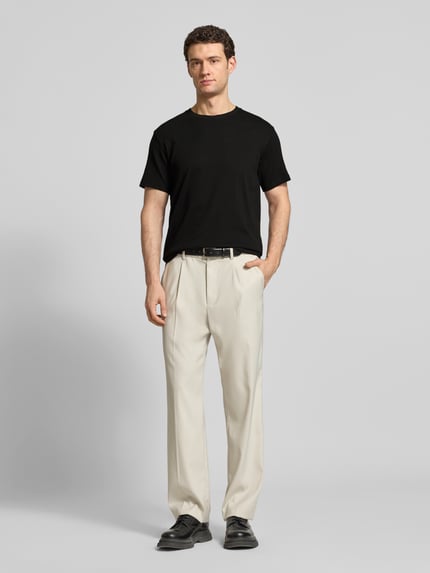 Männermodel trägt Regular Fit T-Shirt aus Baumwoll-Mix Modell 'SPENCER' von SELECTED HOMME, schwarz, fein strukturierte Streifen, Ganzkörperansicht von vorne.