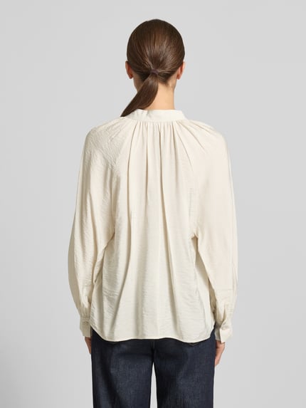 Frauenmodel trägt Bluse aus Viskose-Mix mit Serafino-Ausschnitt von Christian Berg Woman in Creme, lockere Passform, Sportmanschetten, Rückenlänge 61 cm, Ärmellänge 64 cm, Ganzkörperansicht Rückansicht