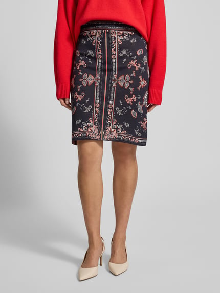 Frauenmodel trägt Knielanger Strickrock im Allover-Look von Marc Cain aus Baumwoll-Viskose-Mix, A-Linie, knielang, Ganzkörperansicht von vorne.