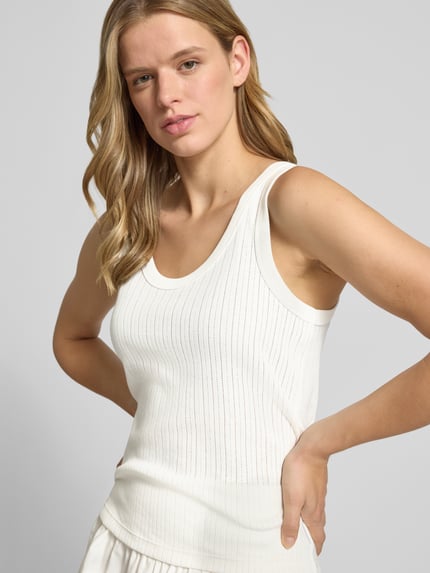 Frauenmodel trägt Regular-Fit Tanktop aus reiner Baumwolle von Marc O'Polo Denim in Weiß mit feiner Rippenstruktur, Nahaufnahme Oberkörper.