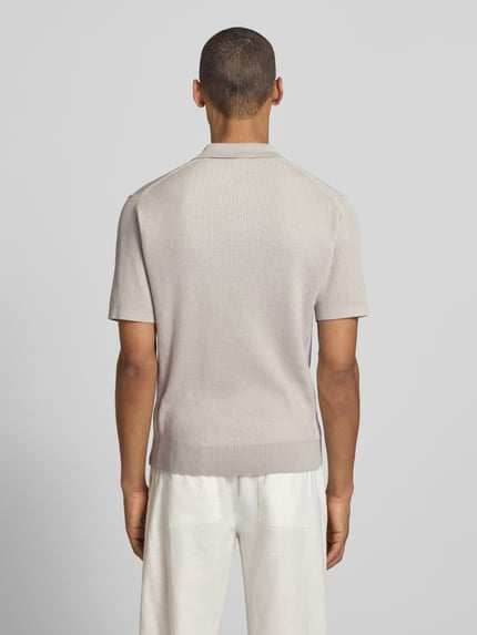 Männermodel trägt Regular Fit Poloshirt aus reiner Baumwolle Modell 'ARAVOLO' von BOSS Orange in Strickoptik, Rückansicht Ganzkörperansicht.