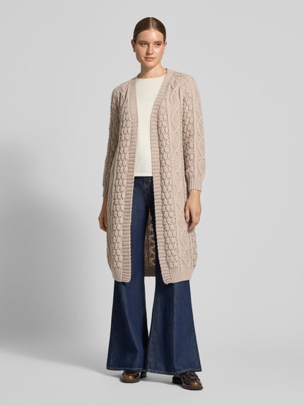 Frauenmodel trägt Longcardigan mit Zopfmuster von Apricot in Beige mit gerippten Abschlüssen, offene Front, Ganzkörperansicht von vorne.