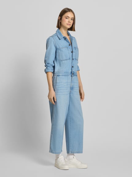 Vrouwenmodel draagt Regular Fit Jumpsuit in Denim-Optik model 'Iconic' van Levi's®, blauwe katoen, lange mouwen, borstzakken, volledige voorkant weergave.