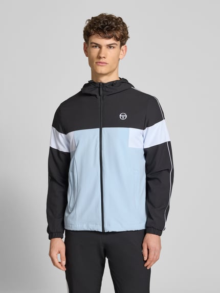 Männermodel trägt Regular Fit Jacke mit Logo-Stitching Modell 'Caspio' von SERGIO TACCHINI im Elastischer-Material-Mix, Pastelltöne, Ganzkörperansicht von vorne, Herren Jacke, Kapuze mit Tunnelzug, Reißverschluss, Eingrifftaschen, elastische Ärmelabschlüsse, Rückenlänge 70 cm, Ärmellänge 68 cm, glatte Struktur.