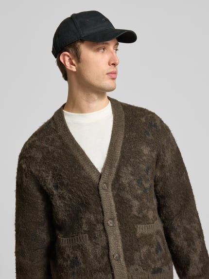 Männermodel trägt Cardigan mit Knopfleiste von ONLY in marmorierter Strickoptik, V-Ausschnitt, Braun, Nahaufnahme Oberkörper.