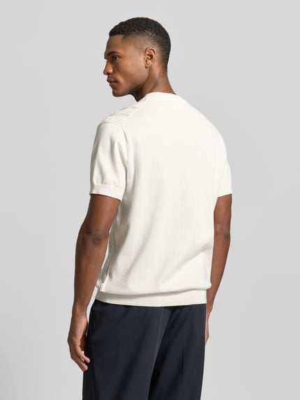 Männermodel trägt T-Shirt mit Zopfmuster von Lindbergh in Weiß, reine Baumwolle, Strick-Optik, gerader Schnitt, Ganzkörperansicht Rückansicht.