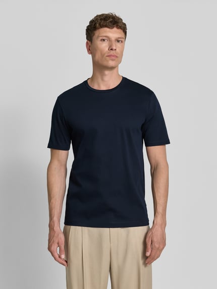 Männermodel trägt T-Shirt mit Rundhalsausschnitt von bugatti in Dunkelblau, Slim Fit aus reiner Baumwolle, Ganzkörperansicht von vorne.