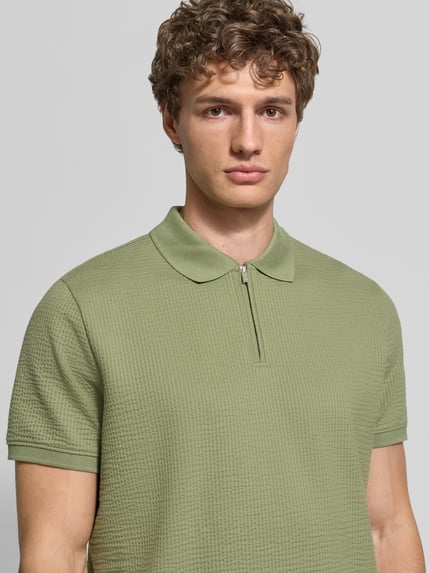 Männermodel trägt Regular Fit Poloshirt mit Strukturmuster von MCNEAL in Hellgrün, Baumwoll-Mix, Reißverschluss, Kurzärmelig, Nahaufnahme Oberkörper.