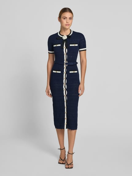 Kobiece modelka nosi Slim Fit Midikleid in Strick-Optik von Self-Portrait, mieszanka bawełny, krój slim fit, imitacja dzianiny, listwa guzikowa, z krótkim rękawem, całkowita długość w rozmiarze S: 126 cm, szerokość klatki piersiowej w rozmiarze S: 41 cm, długość rękawów w rozmiarze S: 23 cm, szerokość w talii w rozmiarze S: 34 cm, granat i biel, widok całej sylwetki z przodu.
