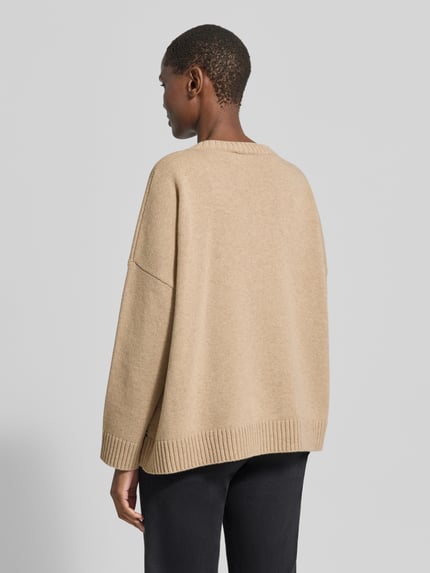 Frauenmodel trägt beigefarbenen Relaxed Fit Pullover aus reiner Wolle Modell 'PAVIDI' von Weekend Max Mara, Damen Pullover, Ganzkörperansicht Rückansicht.