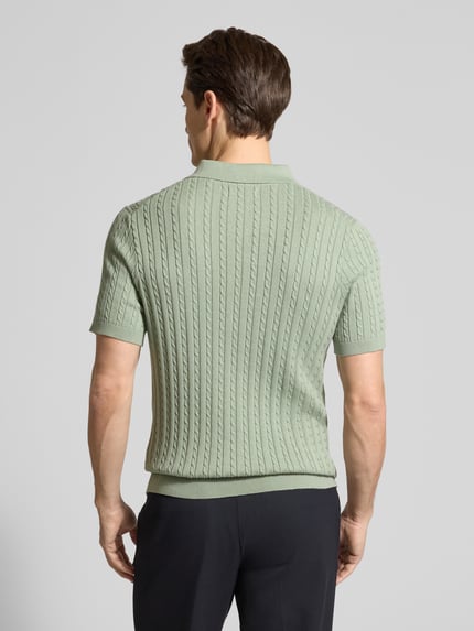 Männermodel trägt Slim Fit Poloshirt in Strick-Optik von Christian Berg Men in Mintgrün, feine Struktur, Kurzarm, Ganzkörperansicht Rückansicht.