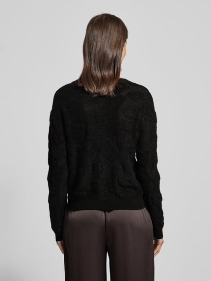 Frauenmodel trägt schwarzen Strickpullover mit Rundhalsausschnitt von Luisa Cerano, Material-Mix mit Alpaka-Anteil, Allover-Look, Regular-Fit, Rückenlänge 50 cm, Ärmellänge 55 cm, Ganzkörperansicht Rückansicht.