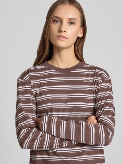 Vrouwenmodel draagt Relaxed Fit Langarmshirt uit puur katoen van JJXX, bruine stof met witte strepen, ronde hals, met lange mouwen, ruglengte maat S 55 cm, bovenlichaam close-up.