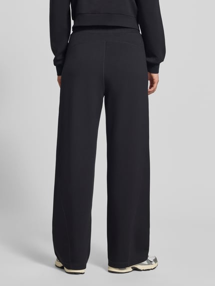 Vrouwenmodel draagt Wide Fit broek uit viscosemix met elastische band van Liu Jo, steekzakken, zwart, binnenbeenlengte 79 cm, Ganzkörperansicht Rückansicht.