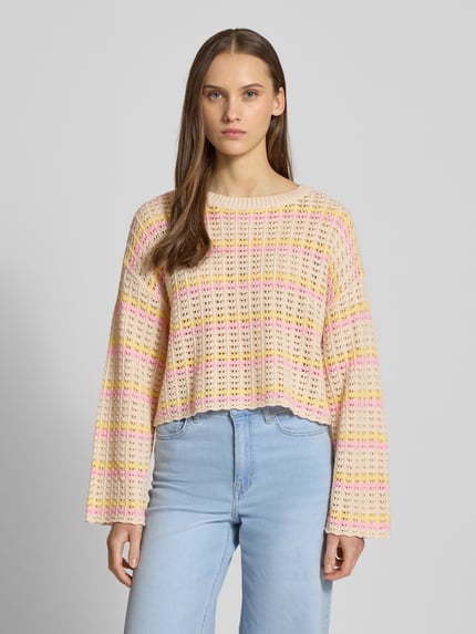 Frauenmodel trägt Regular Fit Strickpullover aus Baumwoll-Mix Modell 'ASA' von ONLY, mehrfarbig, gestreift, Lochstrickmuster, Cropped, Crew Neck, Langarm, Muschelsaum, überschnittene Schultern, Ganzkörperansicht von vorne.