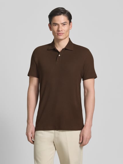 Männermodel trägt Regular Fit Poloshirt aus Baumwoll-Mix Modell 'BLAZE' von SELECTED HOMME, Optik: Unifarben, Piqué, Ganzkörperansicht von vorne.