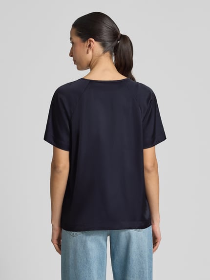 Modelka prezentuje Blusenshirt mit Schlüsselloch-Ausschnitt von comma, mieszanka materiałów z dodatkiem streczu, krój regular fit, rękaw o dł. 1/2, długość tyłu w rozmiarze 36: 60 cm, długość rękawów w rozmiarze 36: 19 cm, gładka faktura, kolor granatowy, widok całej sylwetki z tyłu