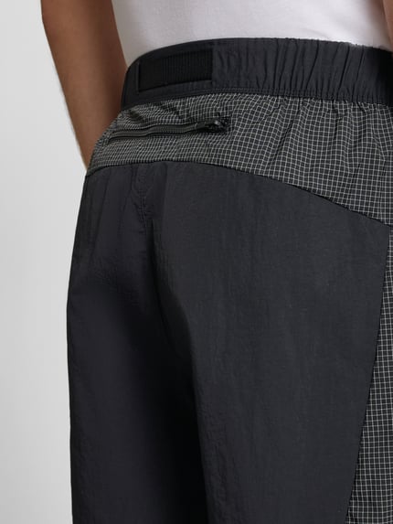 Männermodel trägt Shorts mit Logo und Gürtel van The North Face, regular fit, elastische taille, zwart-grijs, detailopname rug.