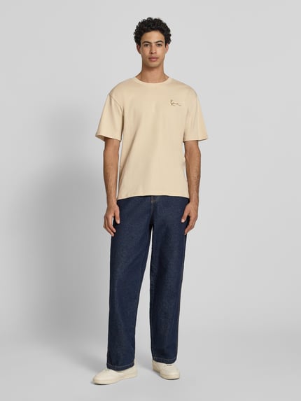 Männermodel trägt Relaxed Fit T-Shirt mit Logo-Stitching von KARL KANI aus Reine Baumwolle mit Rundhalsausschnitt, Herren T-Shirt, Ganzkörperansicht von vorne.