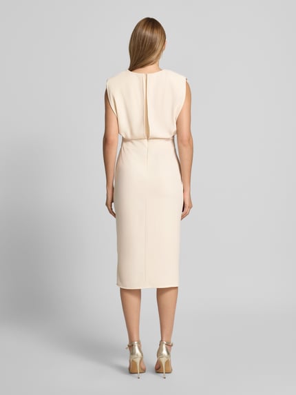 Frauenmodel trägt Cocktailkleid mit Gehschlitz von Rinascimento in Beige, Midikleid mit körpernahem Schnitt, Material-Mix, Ganzkörperansicht Rückansicht.