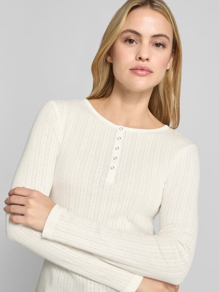 Frauenmodel trägt Longsleeve mit Rundhalsausschnitt und Knopfleiste von Christian Berg Woman aus reiner Baumwolle in Slim Fit, Nahaufnahme Oberkörper.